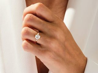 Elegant emerald moissanite ring featuring sparkling diamond cluster around center stone