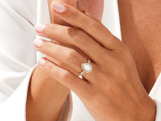 Timeless pear-shaped moissanite engagement ring with halo diamonds and elegant double pavé design