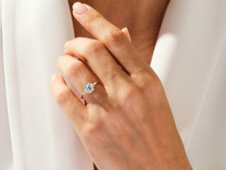 Close-up of 2 carat emerald moissanite ring with luxurious diamond cluster design