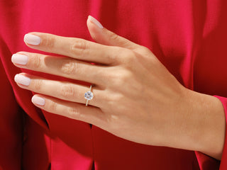 Hand shot of 1.0 CT moissanite ring with natural diamond pave setting.